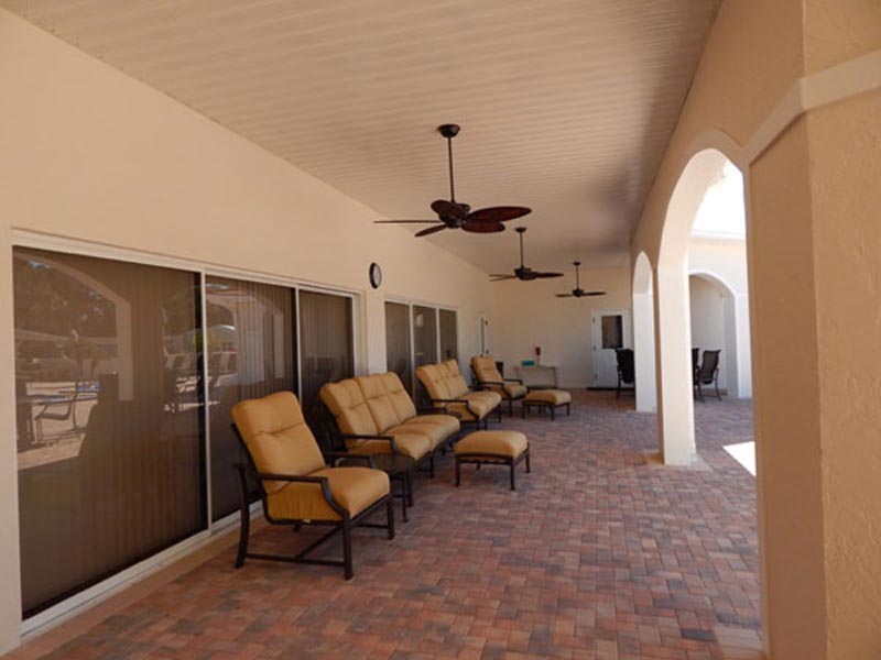 Clubhouse patio with ceiling fans and seating.